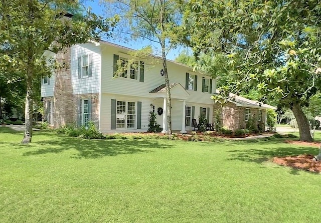 42 Riverdale Dr, Covington, LA 70433 - back of house featuring a lawn and brick siding