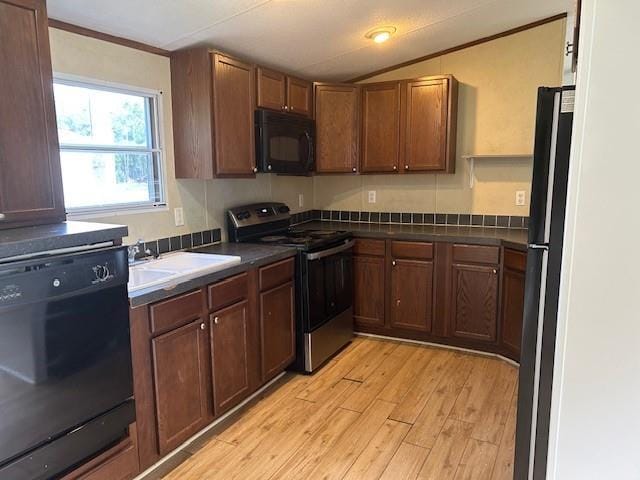 26214 E Sycamore St, Lacombe, LA 70445 - kitchen featuring black appliances, a sink, light wood-type flooring, dark countertops, and crown molding