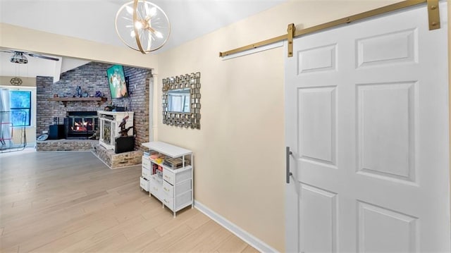 61258 N Military Rd, Slidell, LA 70461 - living area with light wood finished floors, baseboards, a barn door, and a brick fireplace
