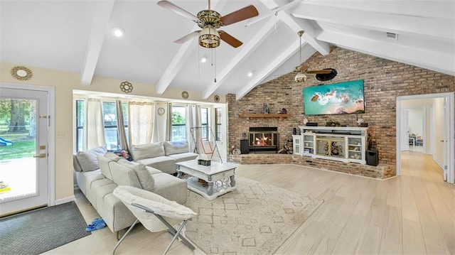 61258 N Military Rd, Slidell, LA 70461 - living area featuring a brick fireplace, wood finished floors, plenty of natural light, brick wall, and a ceiling fan