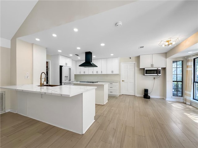 61258 N Military Rd, Slidell, LA 70461 - kitchen with a sink, wall chimney exhaust hood, high quality fridge, stainless steel microwave, and a peninsula