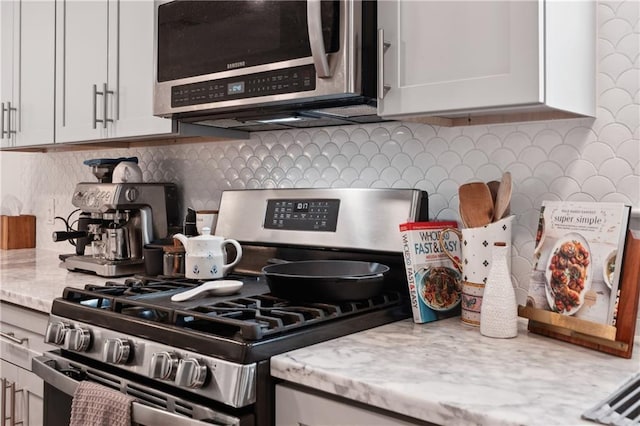 1101 Fairway Dr, Kenner, LA 70062 - kitchen view of appliances with stainless steel finishes, decorative backsplash, and light stone countertops