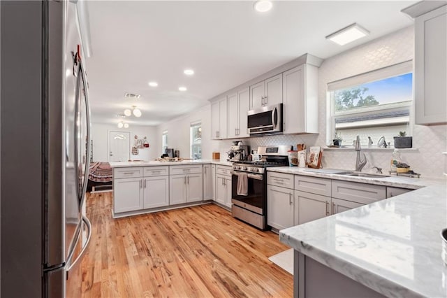 1101 Fairway Dr, Kenner, LA 70062 - kitchen with appliances with stainless steel finishes, a sink, a peninsula, decorative backsplash, and recessed lighting