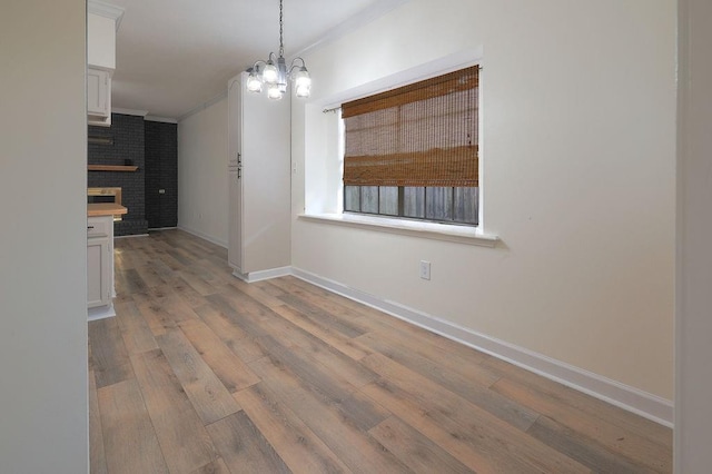 1113 Rose Meadow Loop, Slidell, LA 70460 - unfurnished dining area with wood finished floors, baseboards, a chandelier, ornamental molding, and a fireplace