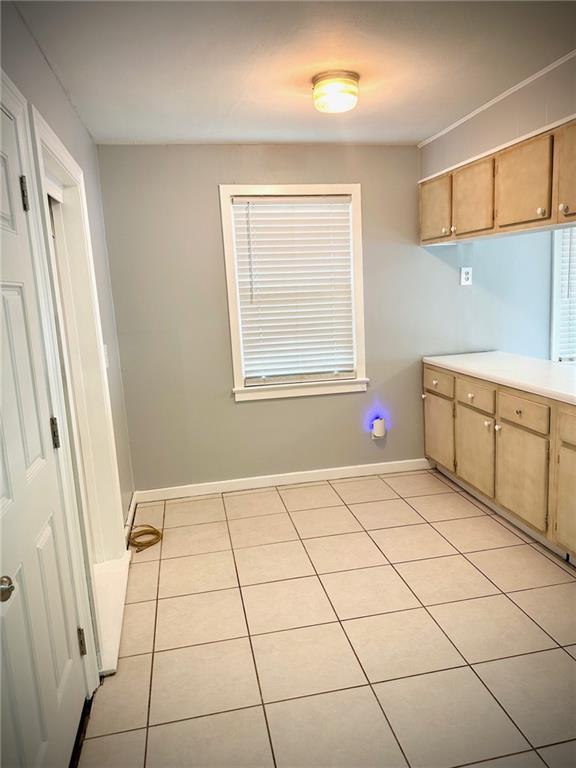 2228 Kentucky Ave, Kenner, LA 70062 - kitchen with light tile patterned flooring, light countertops, and baseboards