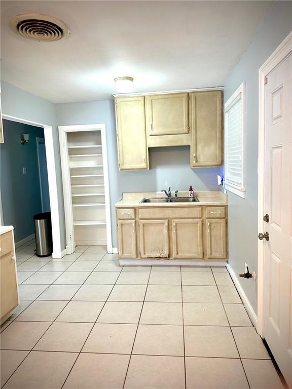 2228 Kentucky Ave, Kenner, LA 70062 - kitchen with a sink, light countertops, light tile patterned floors, and baseboards