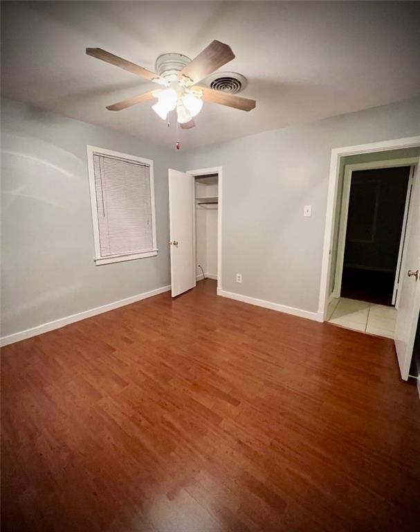 2228 Kentucky Ave, Kenner, LA 70062 - unfurnished bedroom featuring wood finished floors, baseboards, a ceiling fan, and a closet