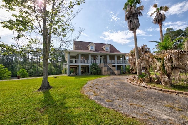 59394 E Harbor Ln, Lacombe, LA 70445 - raised beach house featuring a porch, a front yard, stairway, and curved driveway