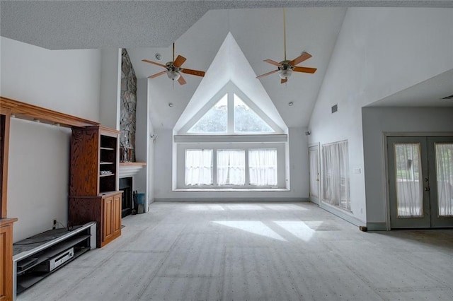 59394 E Harbor Ln, Lacombe, LA 70445 - unfurnished living room with a ceiling fan, high vaulted ceiling, a fireplace, and french doors