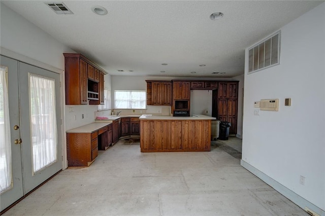 59394 E Harbor Ln, Lacombe, LA 70445 - kitchen with built in microwave, a center island, light countertops, baseboards, and french doors