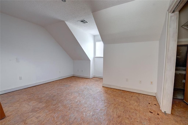59394 E Harbor Ln, Lacombe, LA 70445 - additional living space featuring vaulted ceiling, carpet flooring, baseboards, and a textured ceiling
