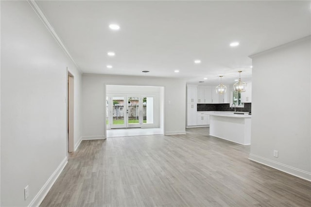 3313 Clifford Dr, Metairie, LA 70002 - unfurnished living room featuring baseboards, recessed lighting, light wood-type flooring, a chandelier, and ornamental molding