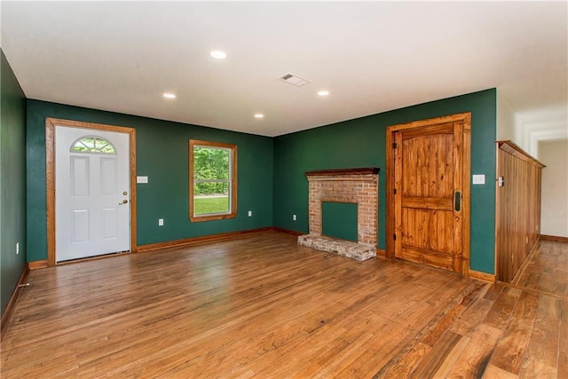 51075 Jenkins Ln, Tickfaw, LA 70466 - unfurnished living room with light wood-style flooring, baseboards, recessed lighting, and a brick fireplace