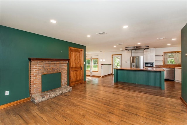51075 Jenkins Ln, Tickfaw, LA 70466 - kitchen featuring appliances with stainless steel finishes, white cabinetry, baseboards, dark wood-style flooring, and a center island