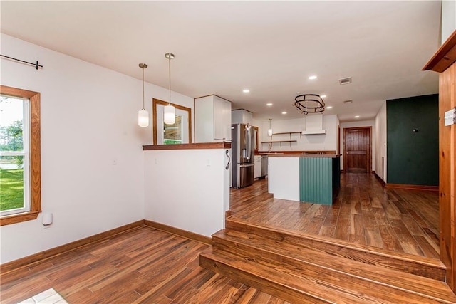 51075 Jenkins Ln, Tickfaw, LA 70466 - kitchen featuring stainless steel refrigerator with ice dispenser, dark wood-style floors, white cabinetry, a center island, and pendant lighting