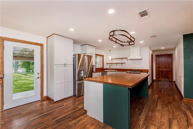 51075 Jenkins Ln, Tickfaw, LA 70466 - kitchen featuring wood counters, appliances with stainless steel finishes, white cabinets, a kitchen island, and dark wood-style flooring
