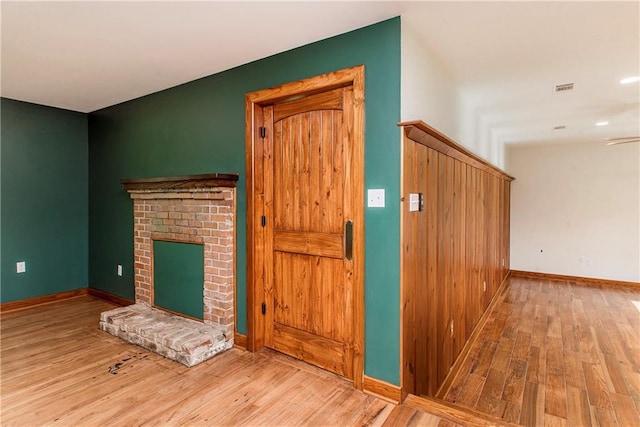 51075 Jenkins Ln, Tickfaw, LA 70466 - unfurnished living room featuring wood finished floors, a brick fireplace, baseboards, and recessed lighting