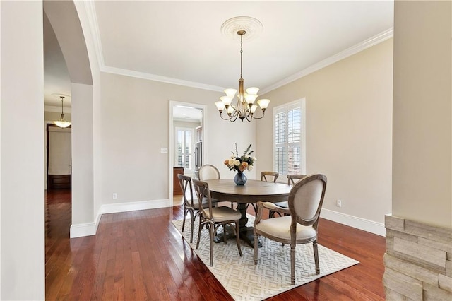 6919 Memphis St, New Orleans, LA 70124 - dining room with hardwood / wood-style flooring, arched walkways, crown molding, and baseboards