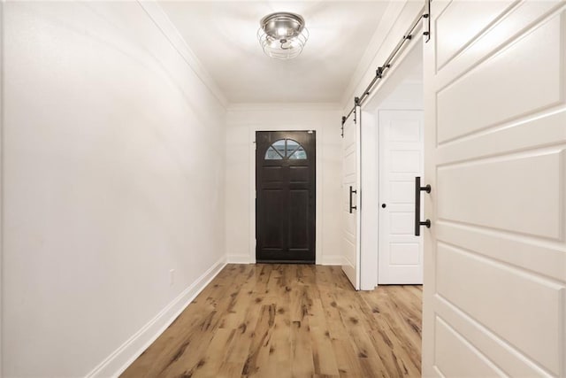 25 Woodvine Ct, Covington, LA 70433 - doorway to outside with a barn door, light wood finished floors, baseboards, and ornamental molding