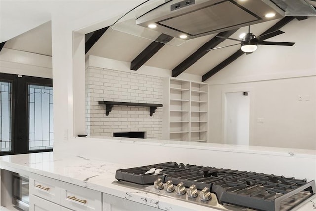 25 Woodvine Ct, Covington, LA 70433 - kitchen featuring stainless steel gas stovetop, white cabinetry, light stone countertops, a brick fireplace, and a ceiling fan