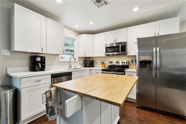 2717 Collette Dr, Marrero, LA 70072 - kitchen with appliances with stainless steel finishes, a sink, white cabinetry, dark wood-type flooring, and recessed lighting