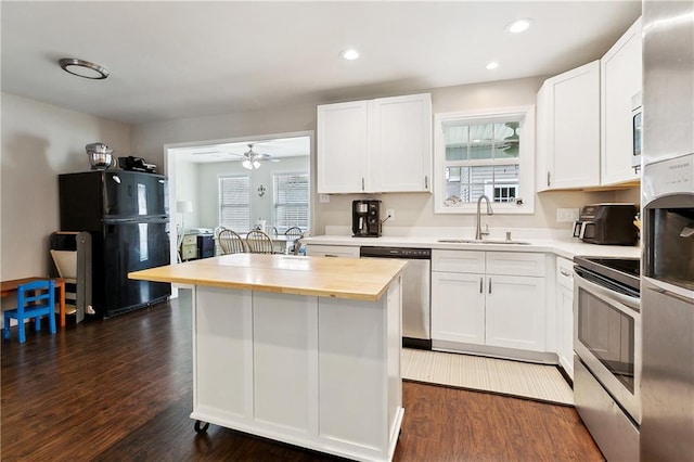 2717 Collette Dr, Marrero, LA 70072 - kitchen featuring stainless steel appliances, a sink, wood counters, white cabinetry, and a center island