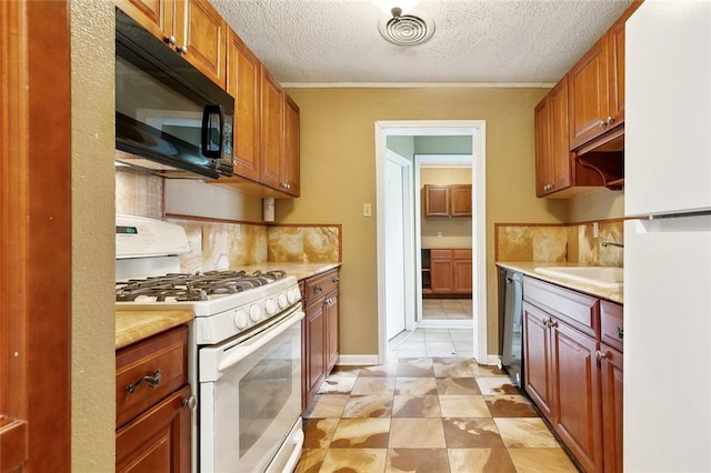 2412 Riverbend Dr, Violet, LA 70092 - kitchen featuring white appliances, a sink, light countertops, a textured ceiling, and light tile patterned floors