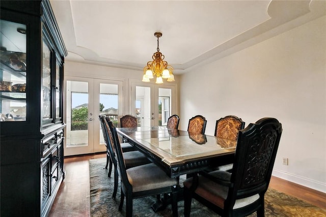 101 Gretel Cv, Slidell, LA 70458 - dining room with french doors, a tray ceiling, a chandelier, dark wood finished floors, and baseboards