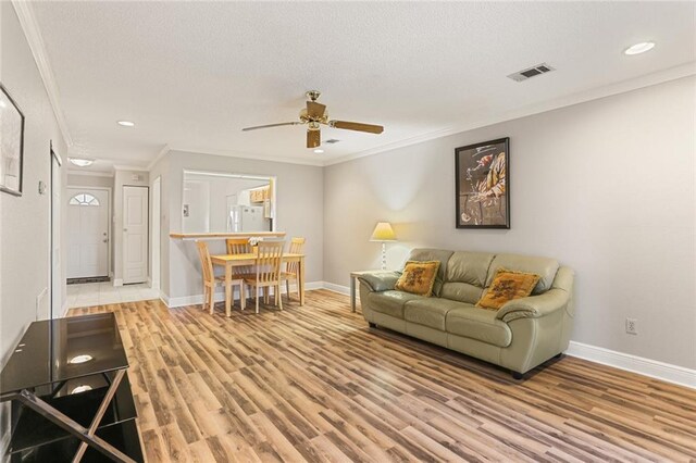 201 Avant Garde Cir Unit 201, Kenner, LA 70065 - living area with ceiling fan, baseboards, wood finished floors, crown molding, and a textured ceiling