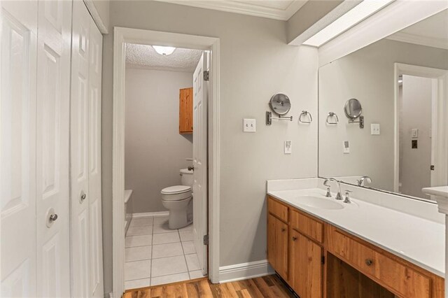 201 Avant Garde Cir Unit 201, Kenner, LA 70065 - bathroom with toilet, vanity, baseboards, ornamental molding, and wood finished floors