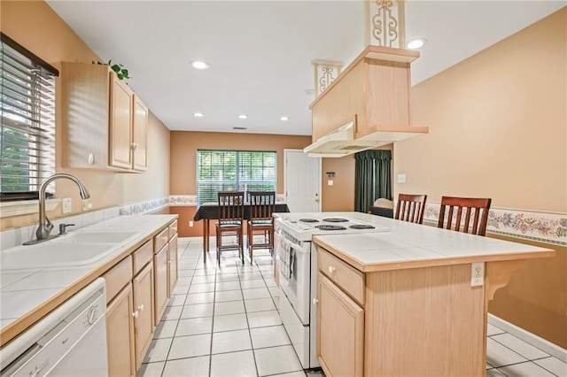70408 7th St, Covington, LA 70433 - kitchen featuring white appliances, tile countertops, light brown cabinets, a sink, and light tile patterned flooring