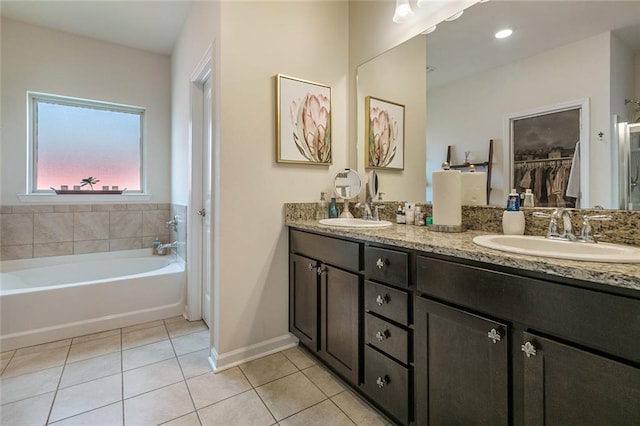 521 Lakeshore Village Ln, Slidell, LA 70461 - bathroom with tile patterned flooring, baseboards, double vanity, a bath, and a spacious closet
