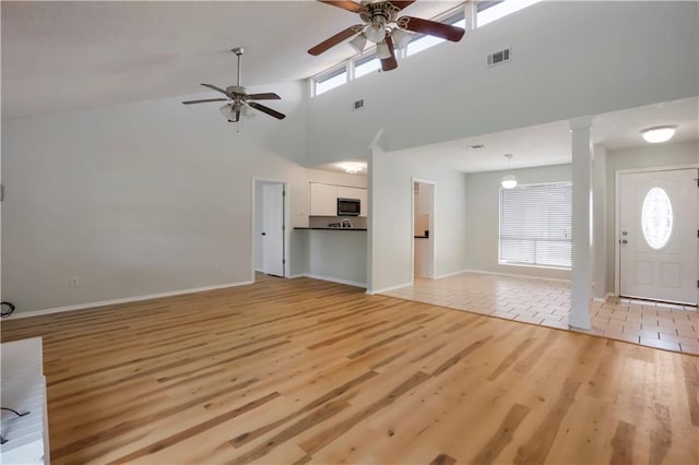 300 Somerset Dr, Slidell, LA 70461 - unfurnished living room featuring ceiling fan, ornate columns, light wood finished floors, a high ceiling, and baseboards