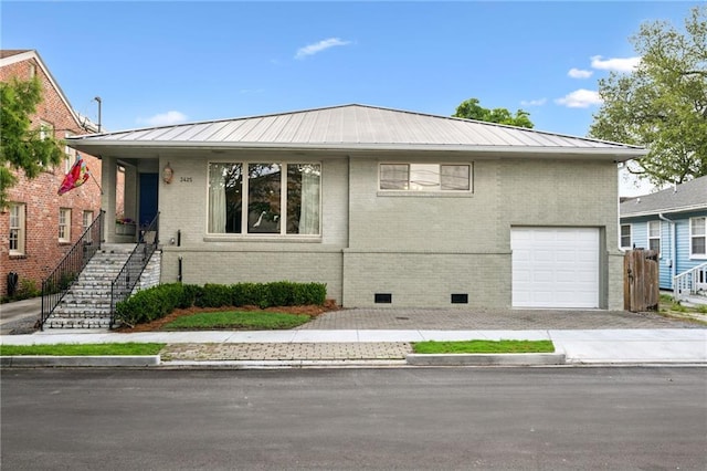 3425 Vincennes Pl, New Orleans, LA 70125 - view of front facade featuring brick siding, metal roof, crawl space, stairs, and concrete driveway