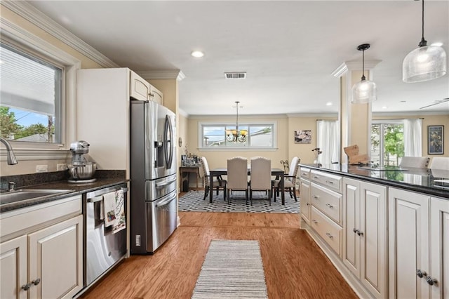 3425 Vincennes Pl, New Orleans, LA 70125 - kitchen with stainless steel appliances, dark countertops, a sink, ornamental molding, and light wood-style floors