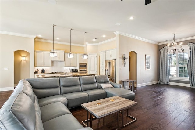801 Rue Bourdeaux, Covington, LA 70433 - living room featuring arched walkways, baseboards, crown molding, dark wood-style flooring, and a chandelier