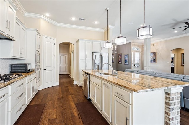 801 Rue Bourdeaux, Covington, LA 70433 - kitchen featuring arched walkways, a sink, appliances with stainless steel finishes, open floor plan, and ornamental molding