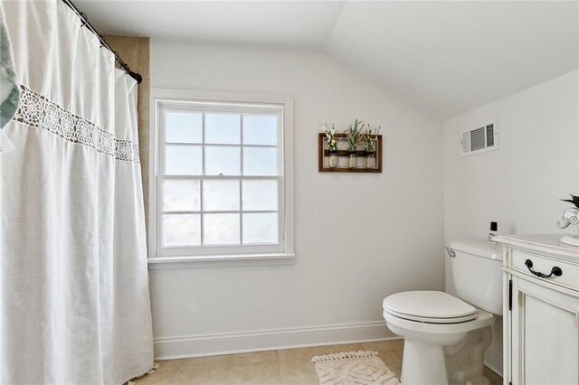 6951 Memphis St, New Orleans, LA 70124 - bathroom with lofted ceiling, tile patterned flooring, toilet, vanity, and baseboards
