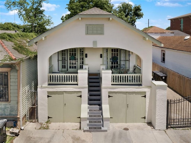 2409-11 St Ann St, New Orleans, LA 70119 - view of front facade with a gate, stairway, covered porch, and an attached garage
