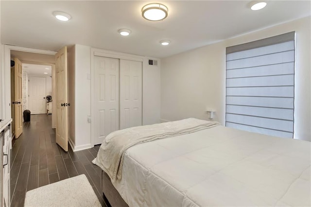 2409-11 St Ann St, New Orleans, LA 70119 - bedroom featuring dark wood-type flooring, a closet, baseboards, and recessed lighting