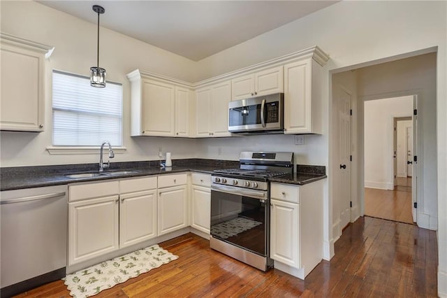 2409-11 St Ann St, New Orleans, LA 70119 - kitchen featuring stainless steel appliances, a sink, dark wood-style flooring, and hanging light fixtures