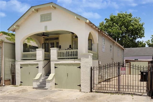 2409-11 St Ann St, New Orleans, LA 70119 - view of front facade featuring a gate, stairs, a ceiling fan, and stucco siding