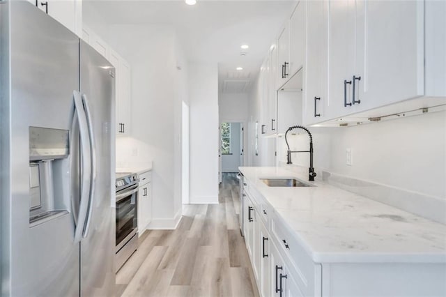 330103 S Saratoga St, New Orleans, LA 70115 - kitchen with appliances with stainless steel finishes, a sink, light wood-style floors, white cabinetry, and recessed lighting