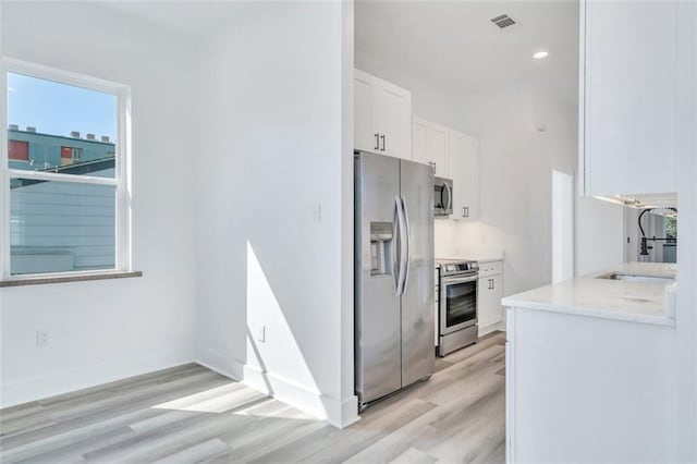 330103 S Saratoga St, New Orleans, LA 70115 - kitchen featuring stainless steel appliances, light wood-style flooring, white cabinetry, baseboards, and recessed lighting