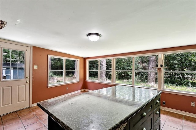 72430 Bullard St, Covington, LA 70435 - kitchen featuring light tile patterned flooring, baseboards, plenty of natural light, and lofted ceiling