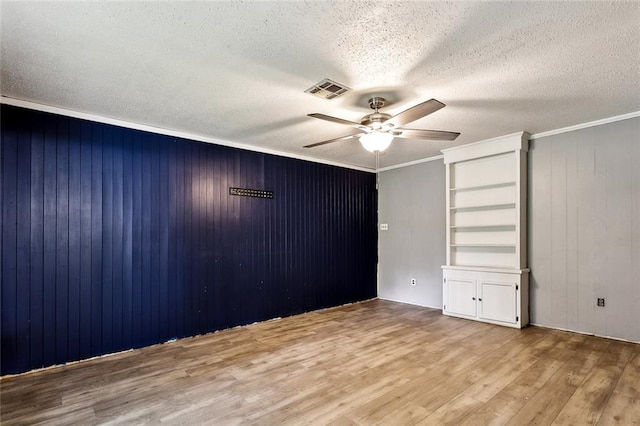 72430 Bullard St, Covington, LA 70435 - unfurnished bedroom featuring wood finished floors, a textured ceiling, a ceiling fan, wooden walls, and ornamental molding