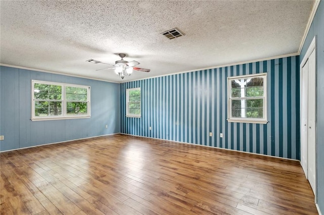 72430 Bullard St, Covington, LA 70435 - empty room with plenty of natural light, ornamental molding, wood-type flooring, ceiling fan, and a textured ceiling