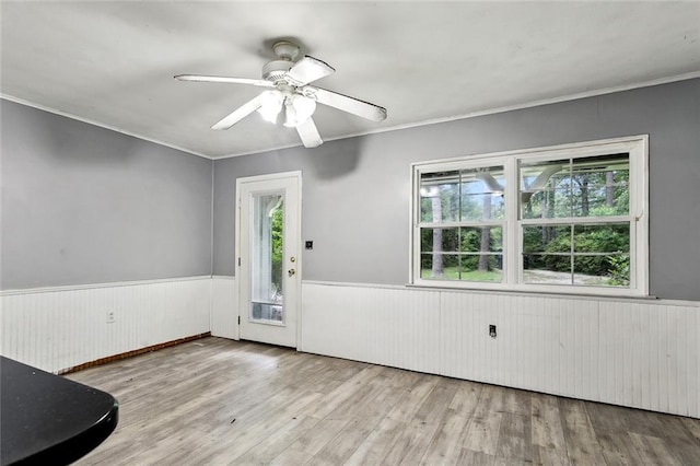 72430 Bullard St, Covington, LA 70435 - unfurnished room with a wainscoted wall, wood finished floors, crown molding, a ceiling fan, and wooden walls