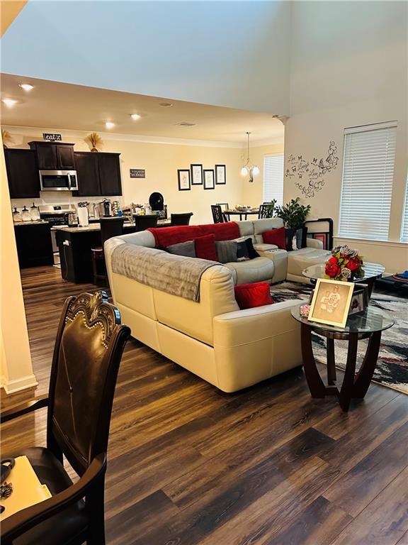1393 Shipyard Dr, Slidell, LA 70461 - living area with dark wood-style flooring, crown molding, a chandelier, and recessed lighting