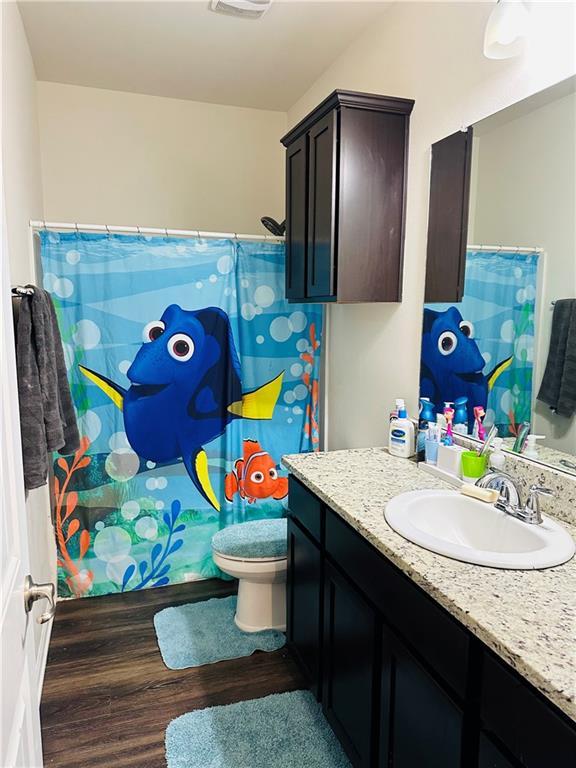 1393 Shipyard Dr, Slidell, LA 70461 - bathroom featuring vanity, wood finished floors, and curtained shower